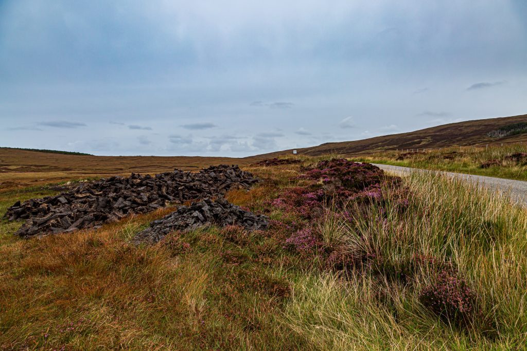 Roadside landscape shot of Scottish peatland and peat briquettes