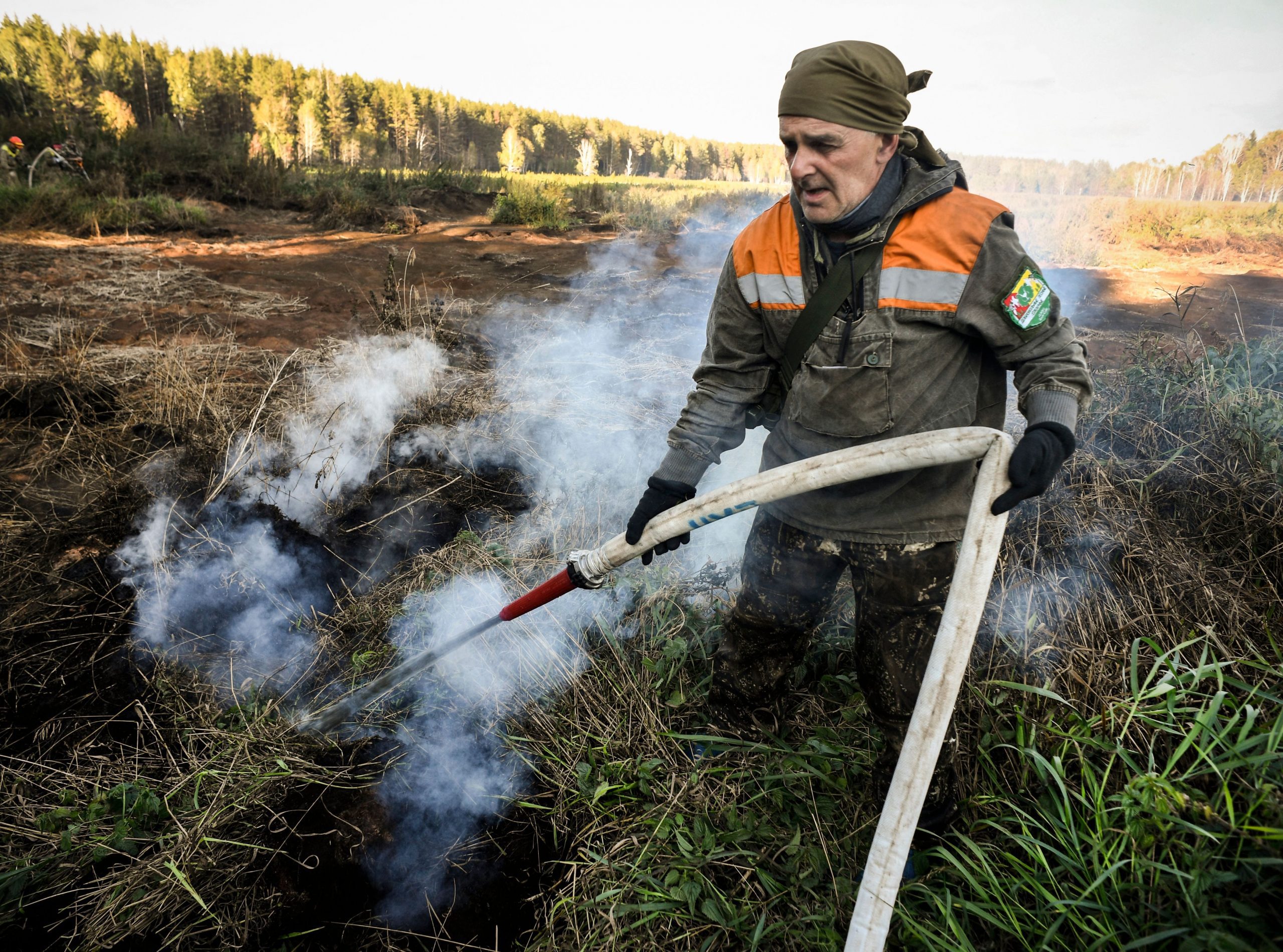 Photograph of a local activist extinguishing a peat fire in a Suzunsky forest next to the village of Shipunovo in Siberia