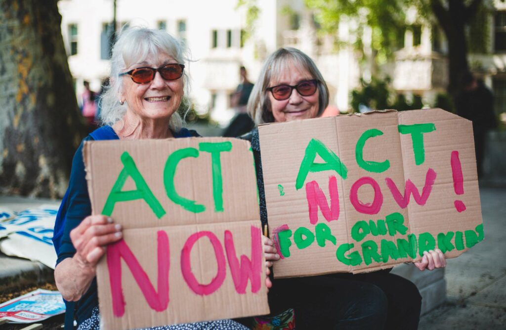 Two women hold signs calling for climate action at a protest in London