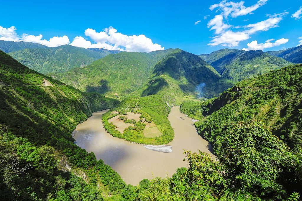 An aerial landscape photo of the Yangtze river winding through green mountainsides