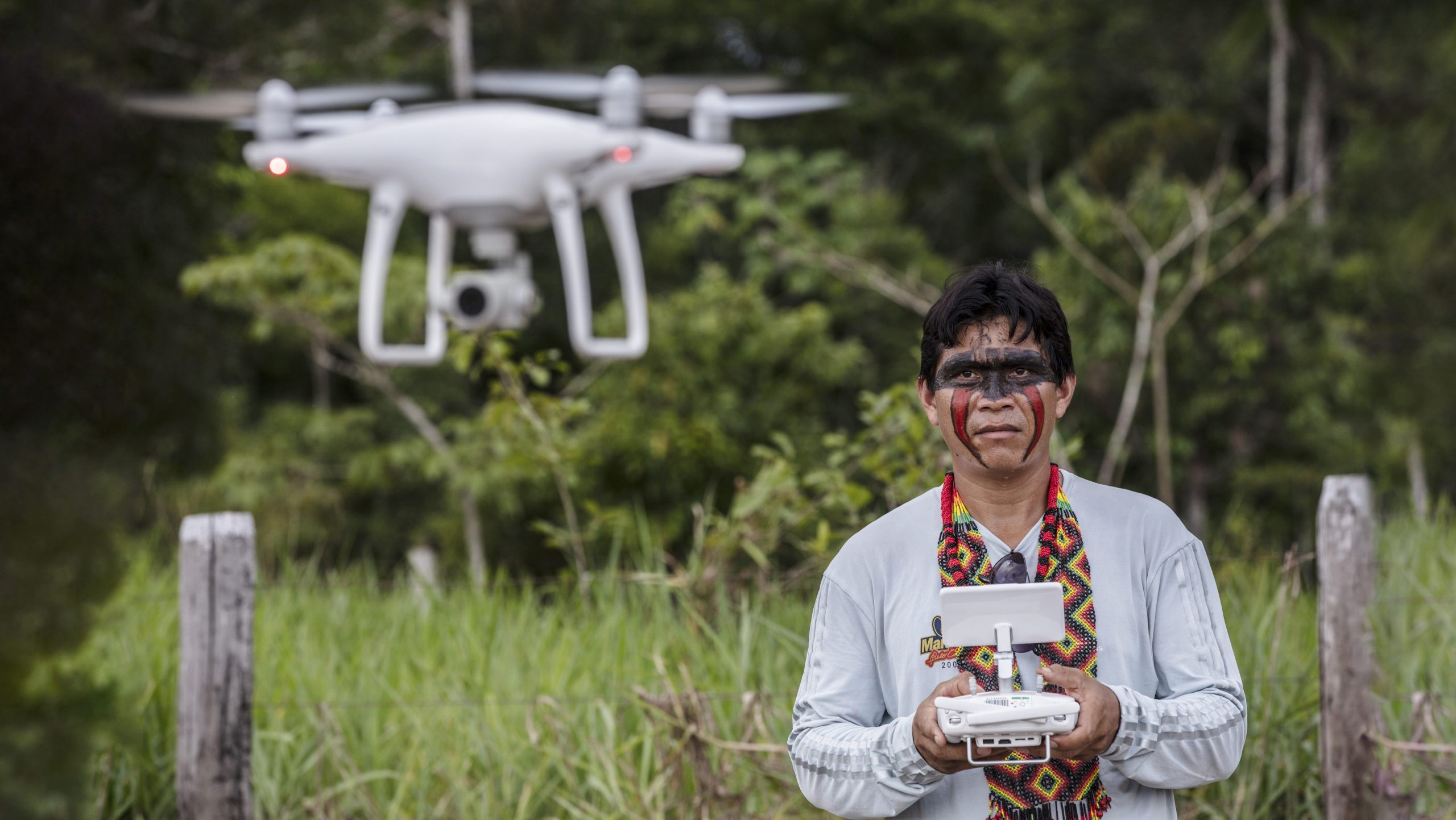 Photograph of an Indigenous person operating a drone, used to monitor protected areas and deforestation in the Amazon rainforest