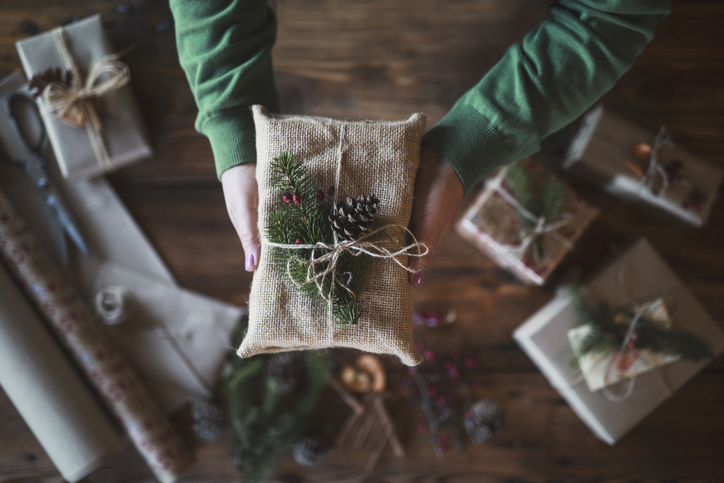 A Christmas present wrapped in fabric with natural decorations