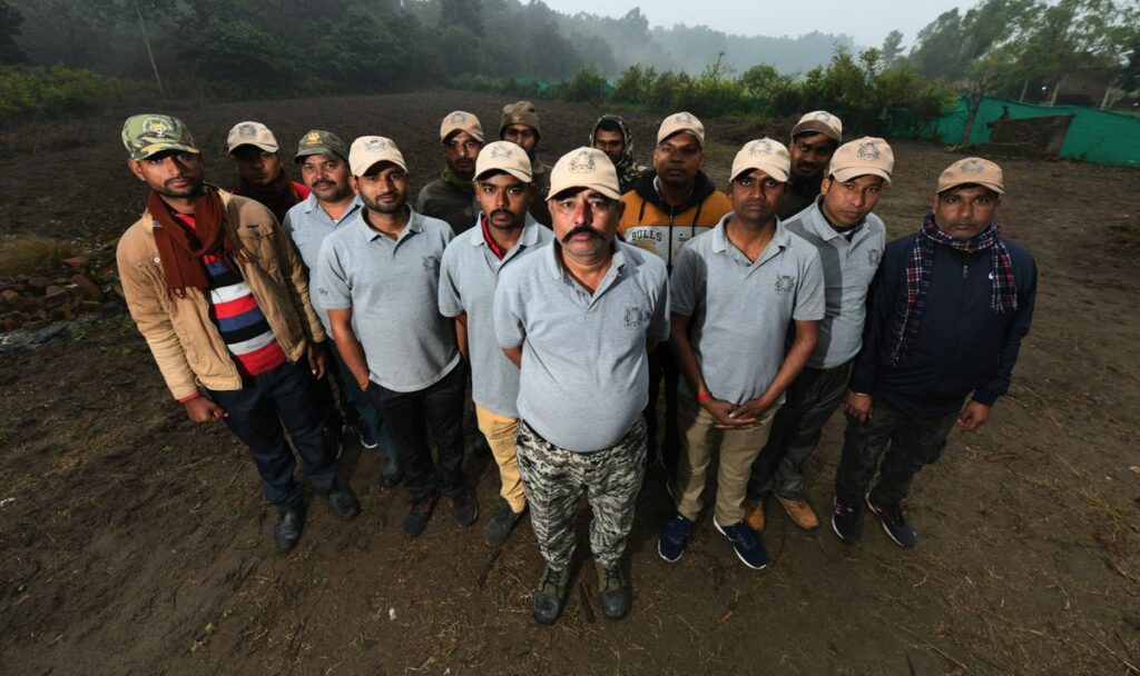 The Tiger Friends pose for a team photo, wearing 'Bagh Mitra' caps and shirts.