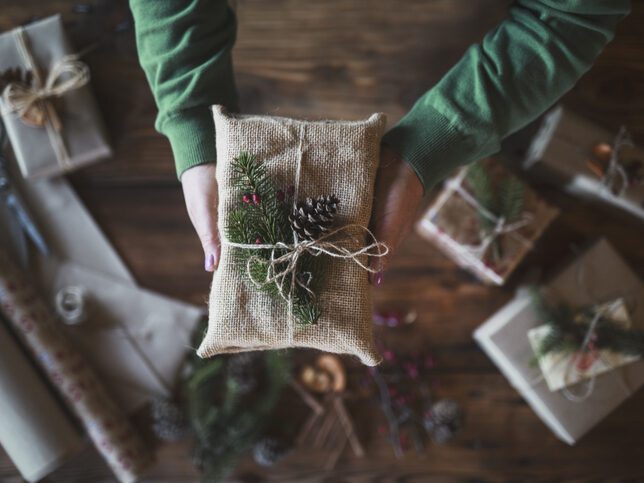 A Christmas present wrapped in fabric with natural decorations