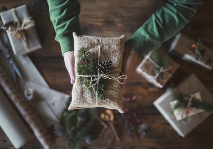 A Christmas present wrapped in fabric with natural decorations