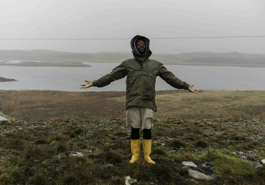 Alexander Thompson-Byer stands in the wet and wind looking out over part of his croft in North Uist, Outer Hebrides