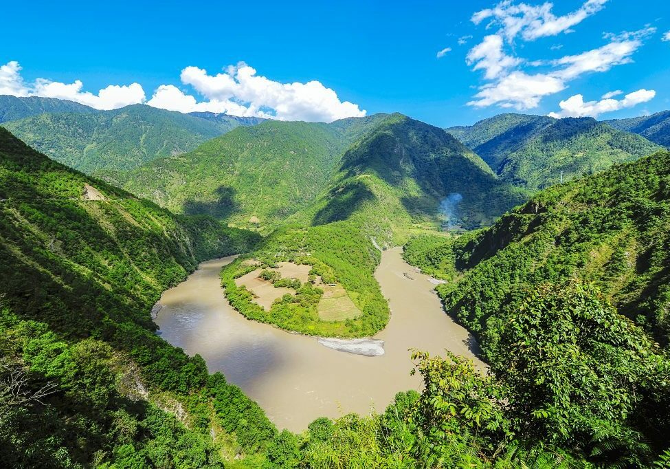 An aerial landscape photo of the Yangtze river winding through green mountainsides